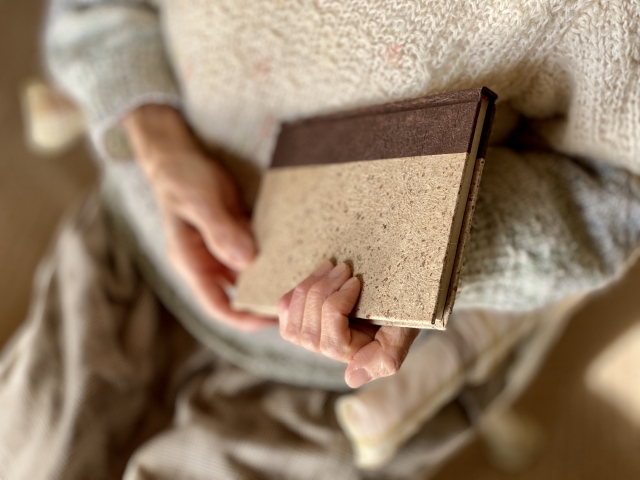 ノートを抱える高齢女性